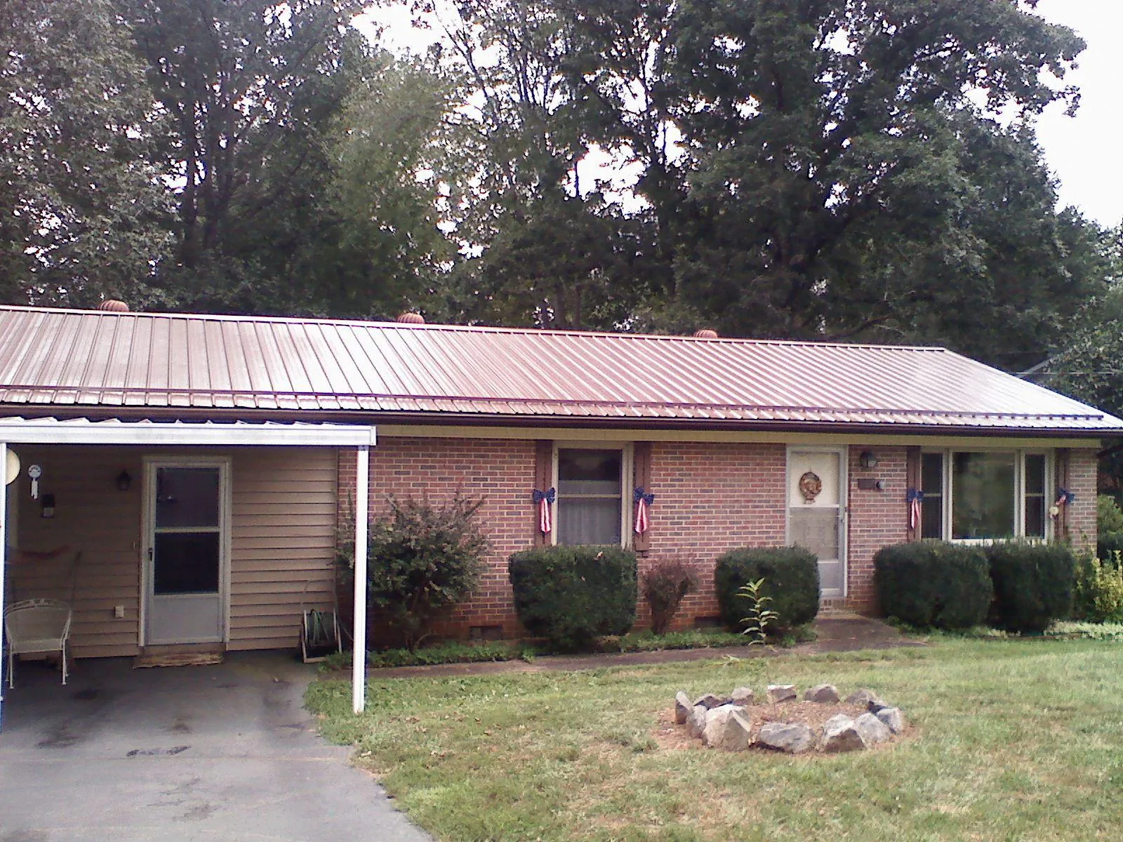 Bronze metal roof and carport on a brick ranch home — Roof Repair work by our crew in Howell